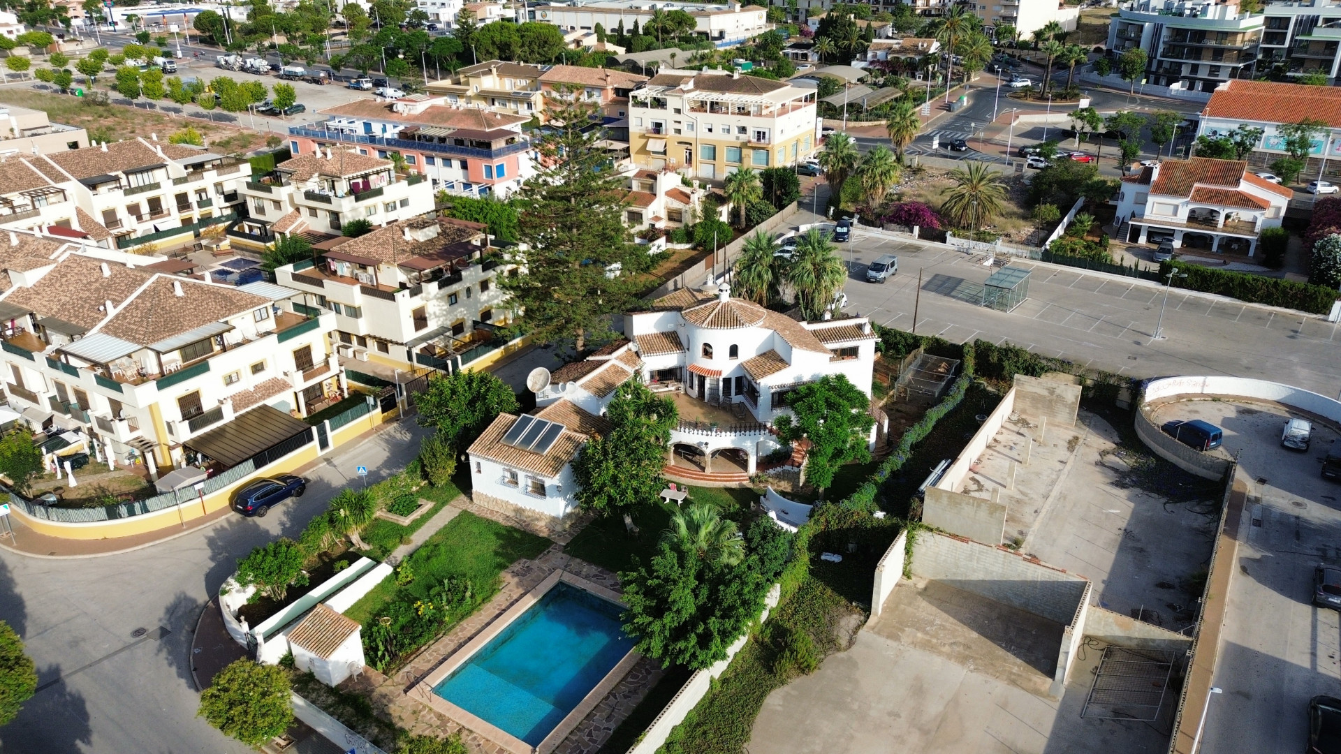 Vue aérienne de la villa avec piscine bleue, entourée de jardins et de verdure à Jávea.