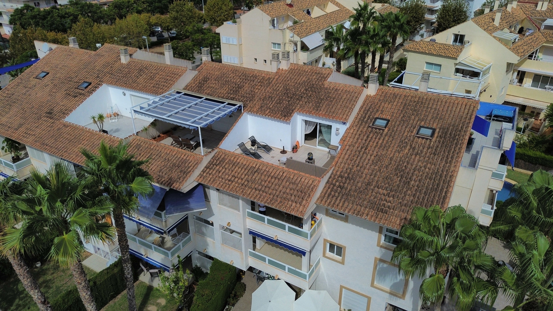 Vue aérienne du penthouse en duplex avec terrasse ensoleillée, store et tuiles en terre cuite à Jávea.