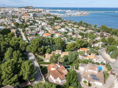 Vue aérienne de la villa avec son toit en tuiles rouges et sa piscine privée, située dans un quartier résidentiel verdoyant de Dénia, face au port et à la mer.