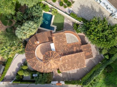 Vue aérienne de la villa, mettant en valeur ses toits de tuiles rouges, sa piscine privée avec boussole et ses jardins méditerranéens luxuriants.