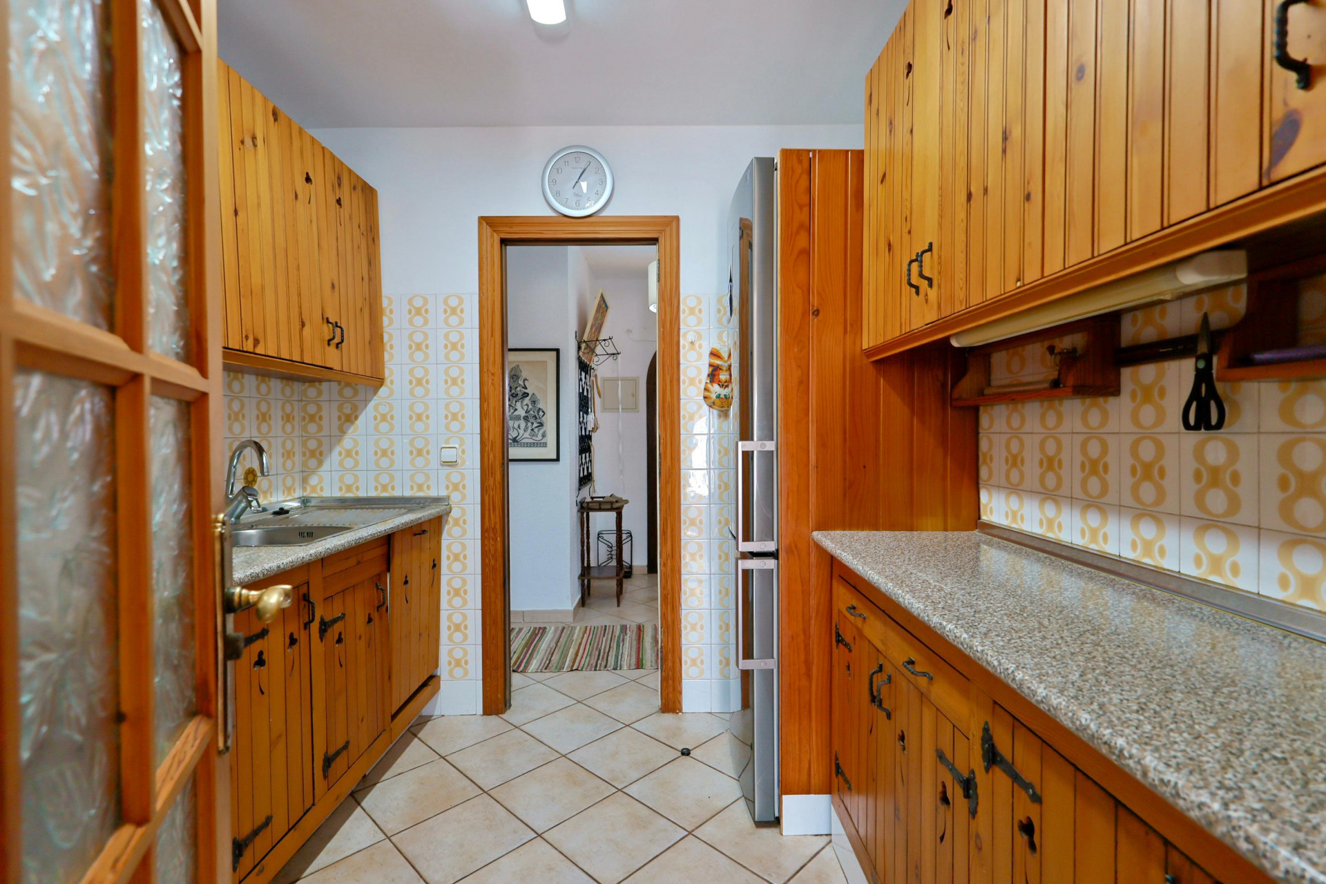 Cuisine rustique avec meubles en bois et comptoir en granit.
