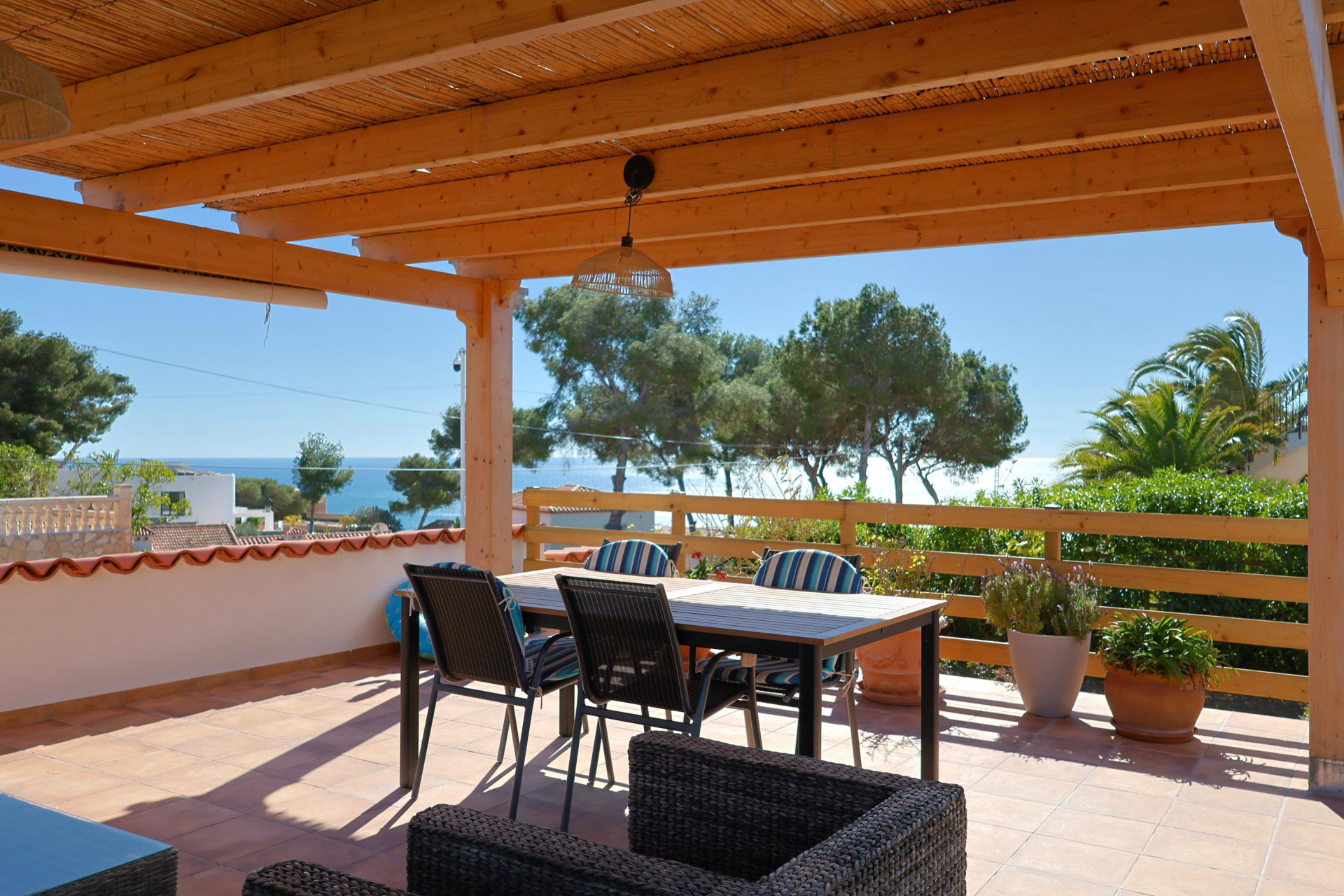 Terrasse couverte avec vue sur la mer et mobilier de salle à manger.