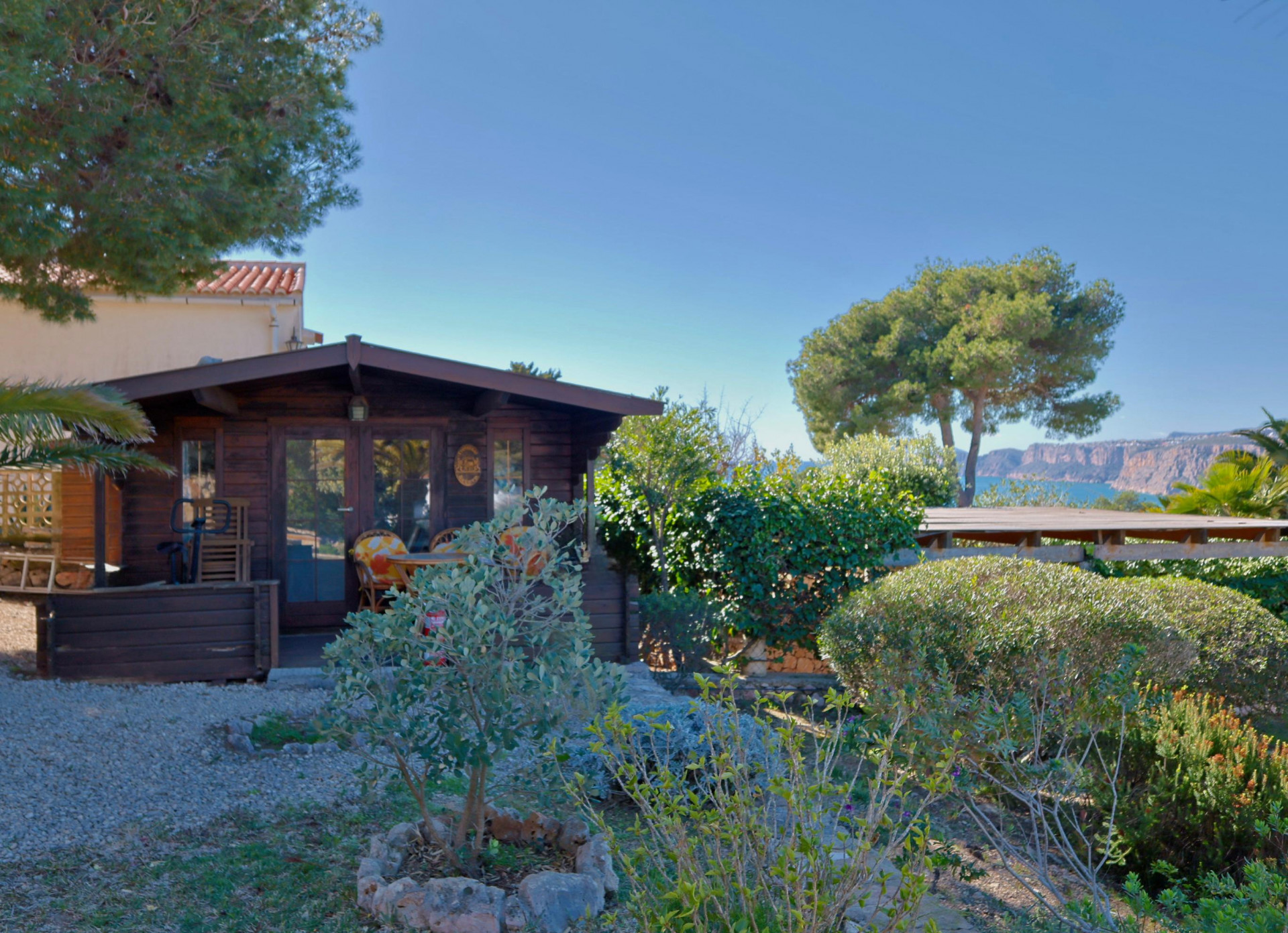 Vue de la cabane en bois, avec jardin méditerranéen et vue sur la mer à Jávea.