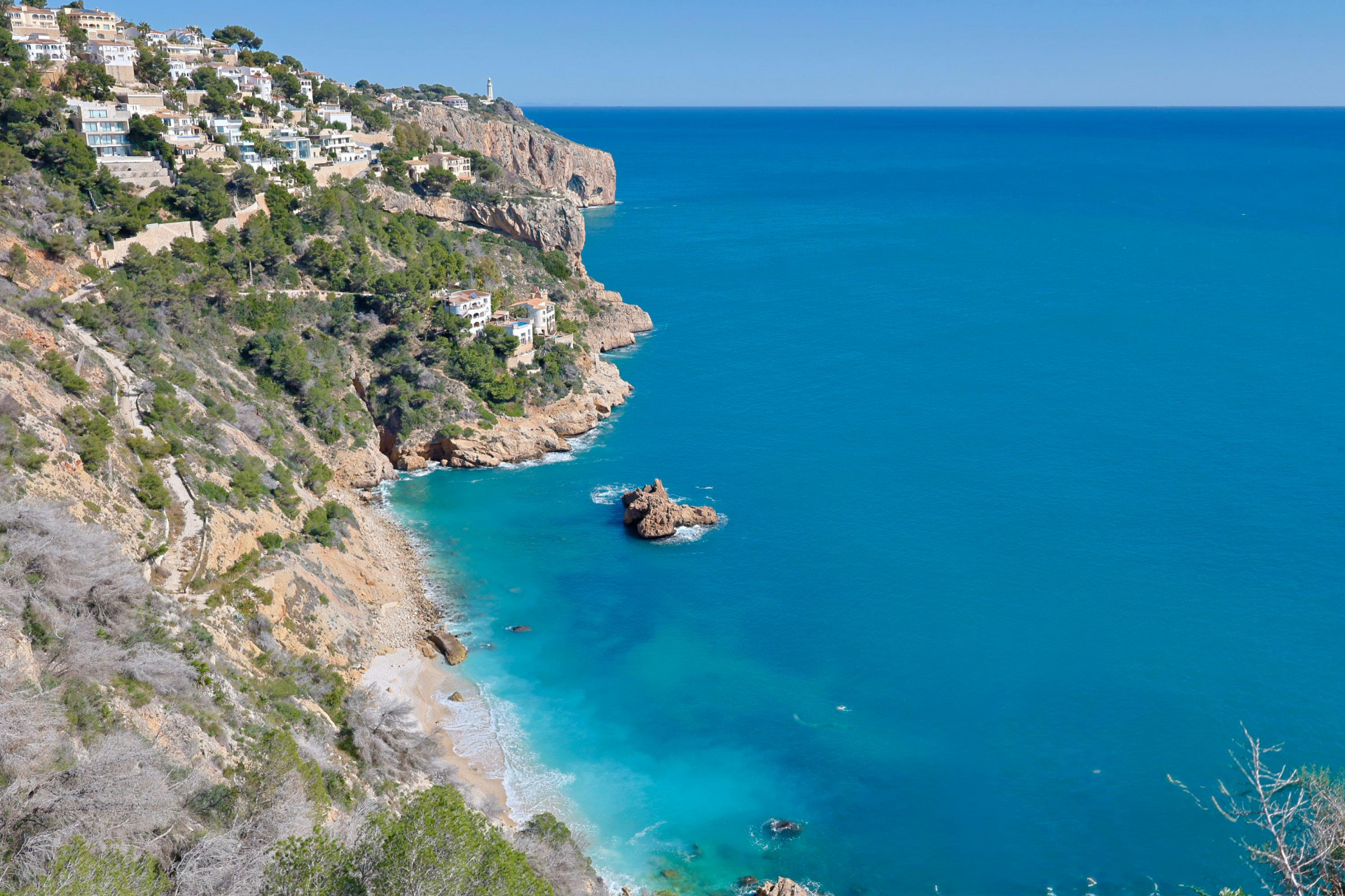 Vue panoramique sur la côte rocheuse de Jávea et ses eaux turquoise.