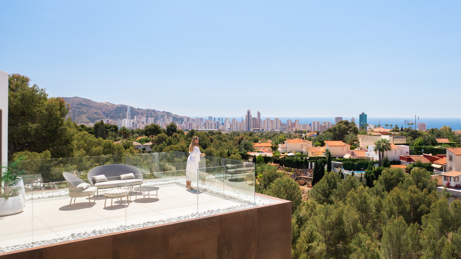 Terrasse avec vue panoramique sur la ville et mobilier d'extérieur moderne.