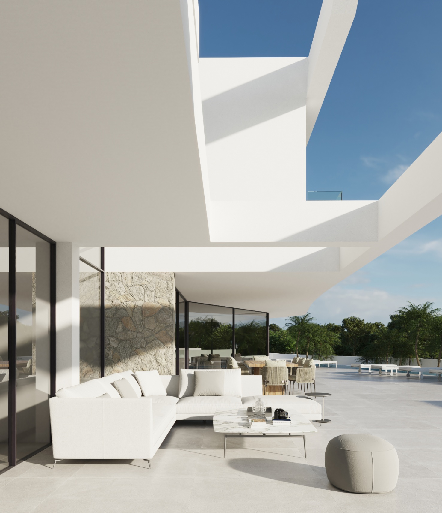 Terrasse principale avec salon extérieur, canapés de designer et finitions en pierre naturelle sous une structure architecturale blanche aux lignes épurées.