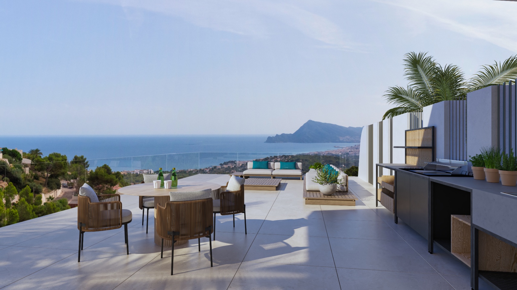 Terrasse extérieure avec cuisine d'été, coin repas et salon de détente. Elle offre une vue panoramique sur la mer Méditerranée et la côte d'Altea derrière un garde-corps en verre.