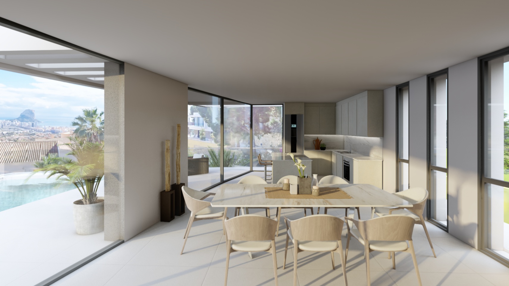 Espace dînatoire ouvert avec cuisine minimaliste et grandes baies vitrées offrant un accès direct à la terrasse, à la piscine et au Peñón de Ifach.