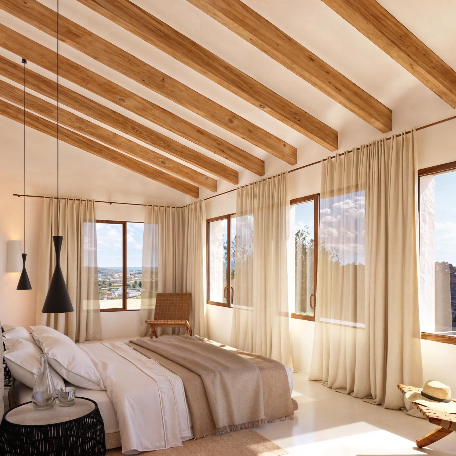 Chambre avec poutres apparentes en bois, grandes fenêtres à cadre en bois et lumière naturelle offrant une vue panoramique sur la mer.