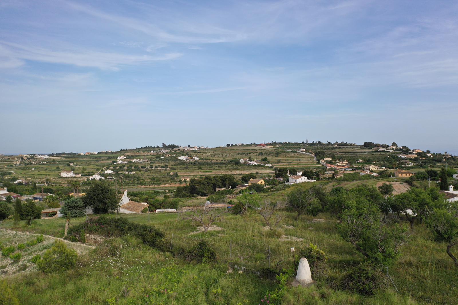 Vue panoramique sur les environs naturels avec des collines en terrasses et une végétation méditerranéenne sous un ciel dégagé.