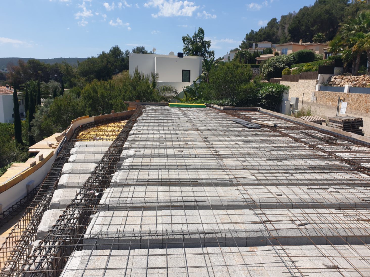 Phase de construction actuelle montrant la dalle de compression avec poutrelles, entrevous et treillis soudé sur un terrain surélevé à Jávea.