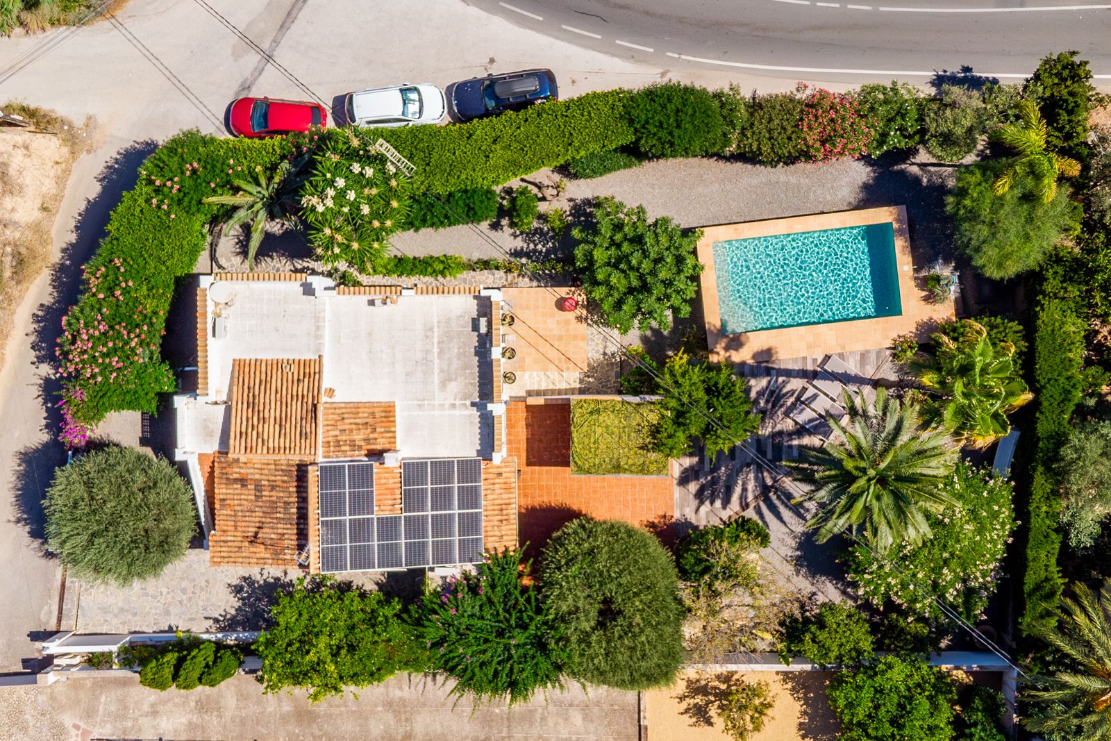 Vue aérienne montrant l'agencement de la parcelle avec sa piscine privée, l'installation de panneaux solaires sur le toit et son jardin méditerranéen arboré.
