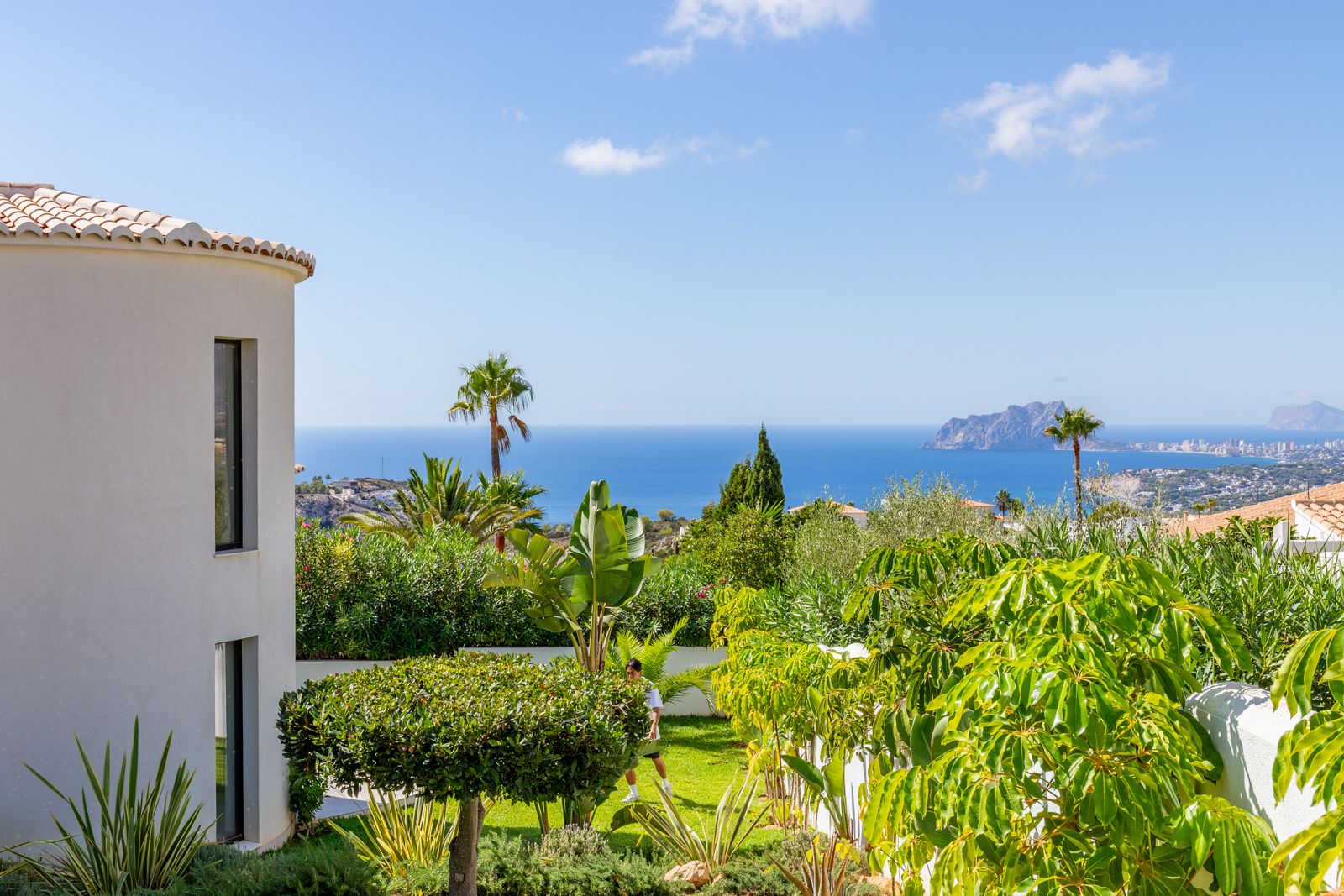 Vues panoramiques sur la mer Méditerranée et le Peñón de Ifach depuis le jardin paysager bordant la façade courbe de la villa.