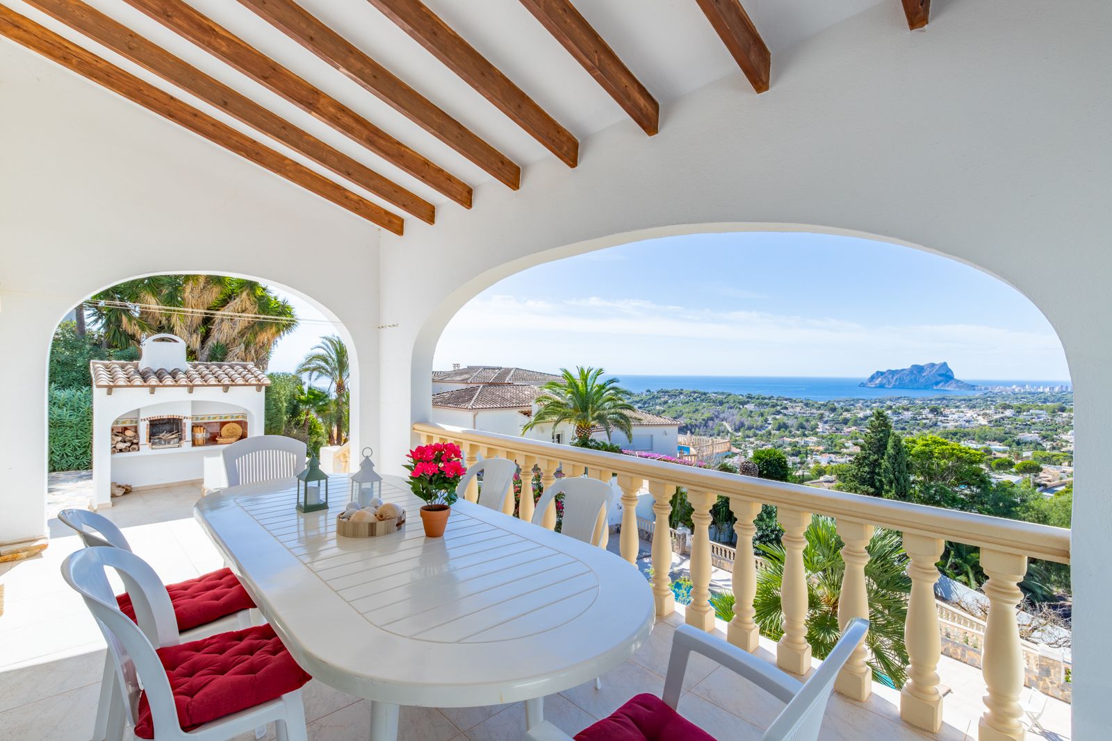 Terrasse couverte avec poutres en bois et coin repas, offrant une vue panoramique sur la mer Méditerranée et le Peñón de Ifach.