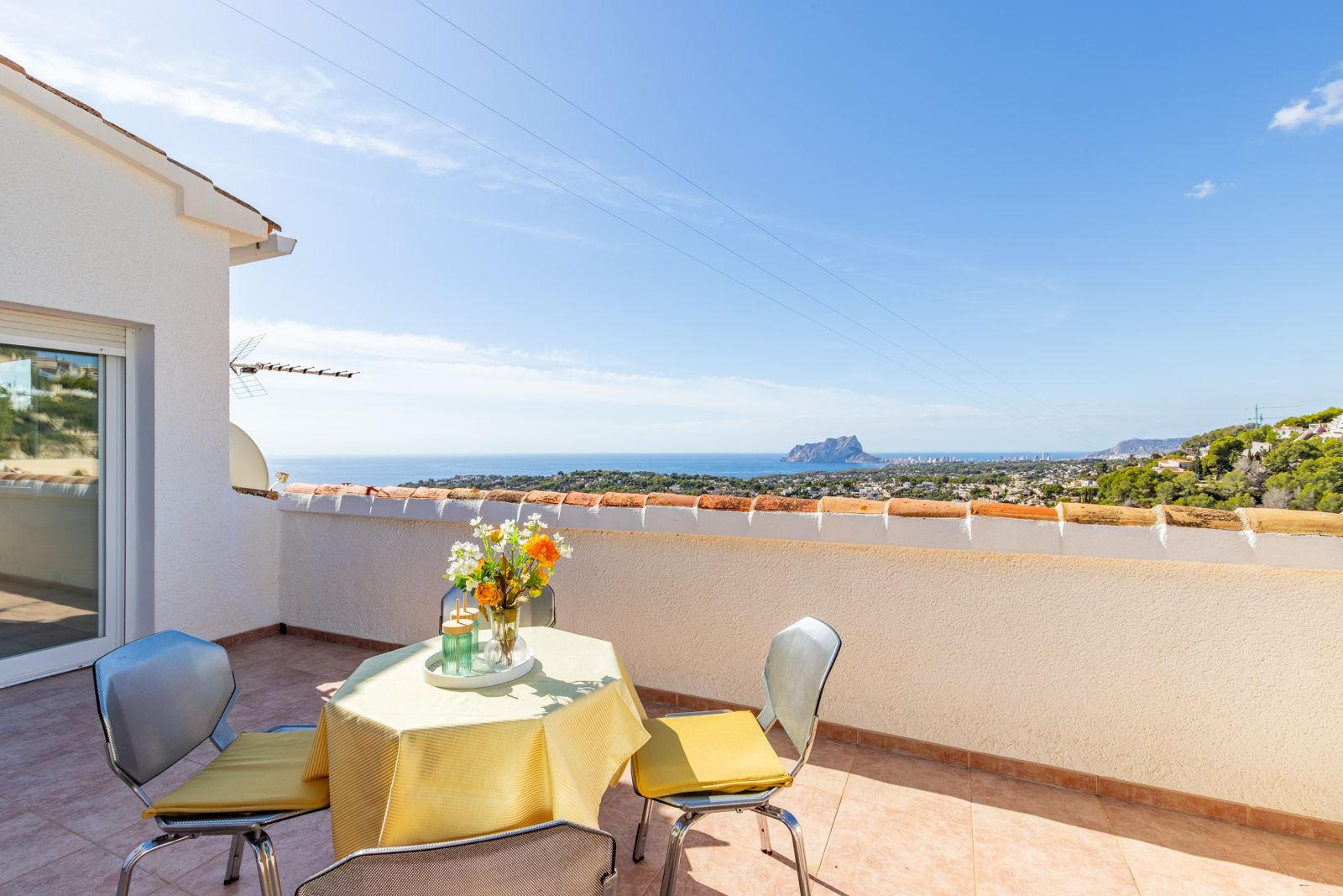 Terrasse surélevée avec carrelage en céramique offrant une vue panoramique sur la mer Méditerranée et le Peñón de Ifach, dotée d'un coin repas extérieur.