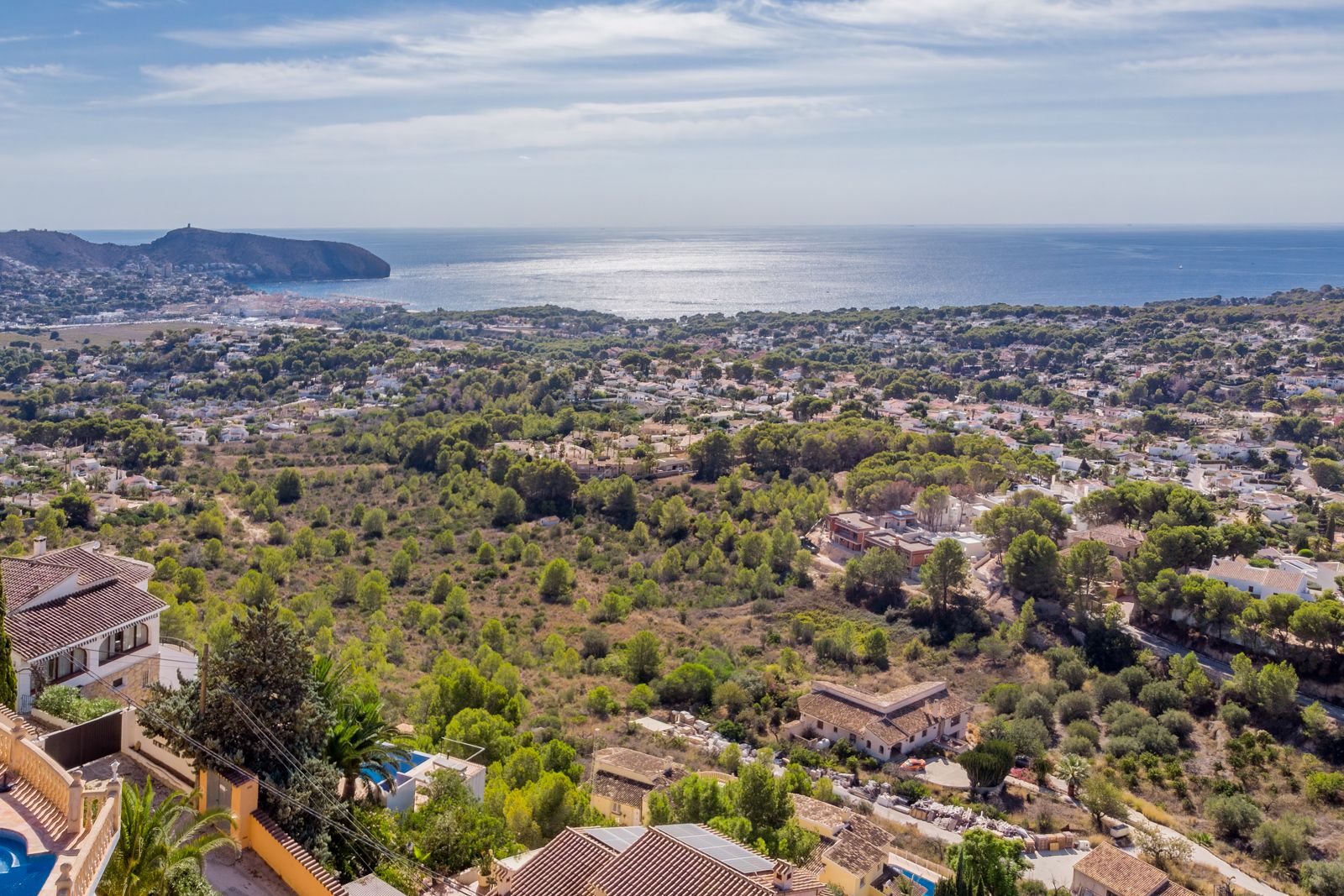 Vues panoramiques sur la mer Méditerranée et le Cap d'Or depuis Benimeit, illustrant le paysage côtier verdoyant et le littoral de Moraira.