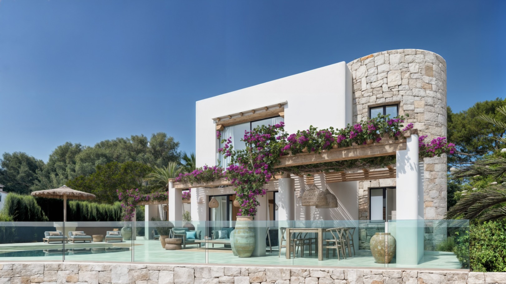 Façade de style ibizane alliant pierre naturelle et crépi blanc, avec une pergola en bois fleurie surplombant l'espace dînatoire extérieur et la piscine.