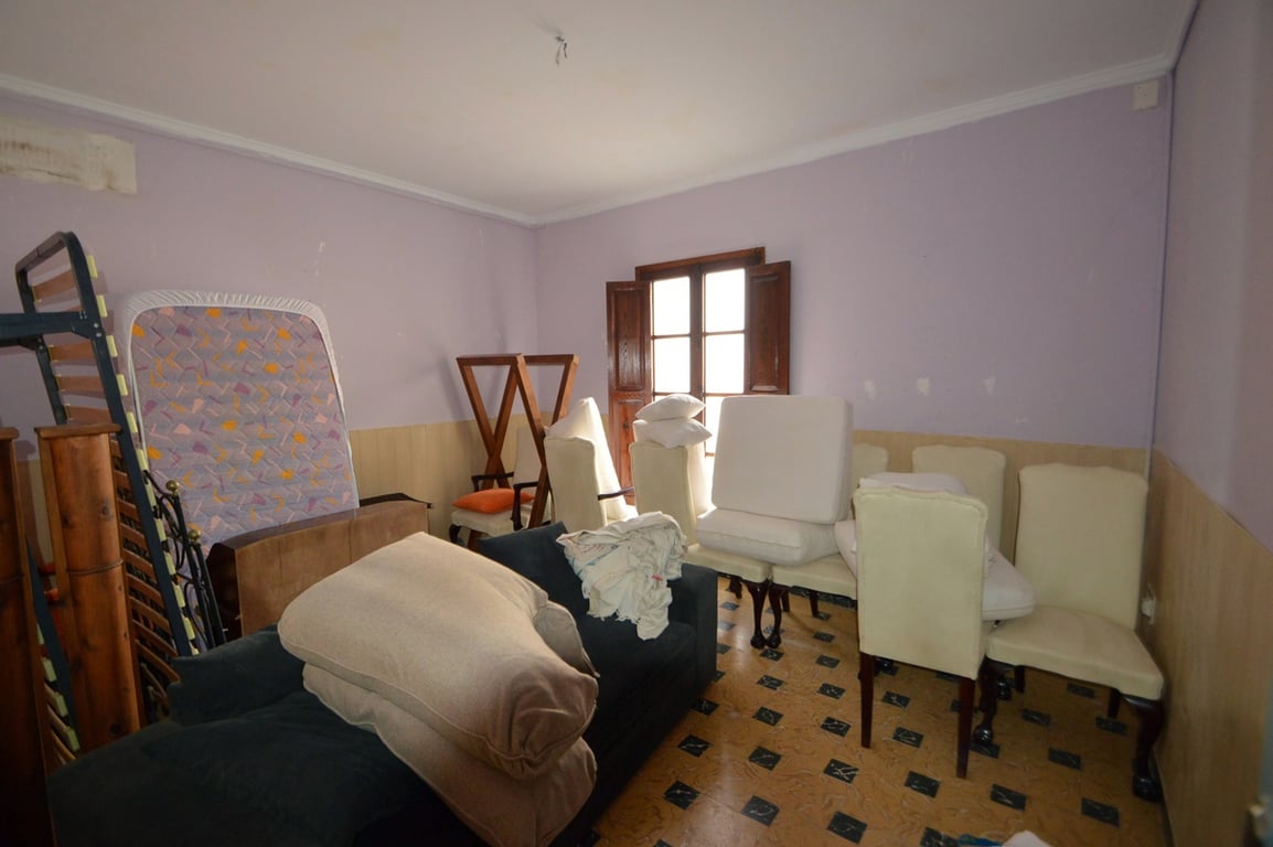 Chambre spacieuse avec murs lavande et soubassement en bois, sol en carrelage à motifs et fenêtre en bois avec volets intérieurs d'origine.