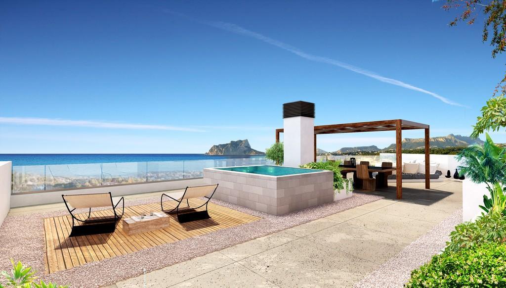 Toit-terrasse avec piscine surélevée, espace dînatoire sous pergola en bois et vue panoramique sur la mer Méditerranée et le Peñón de Ifach.