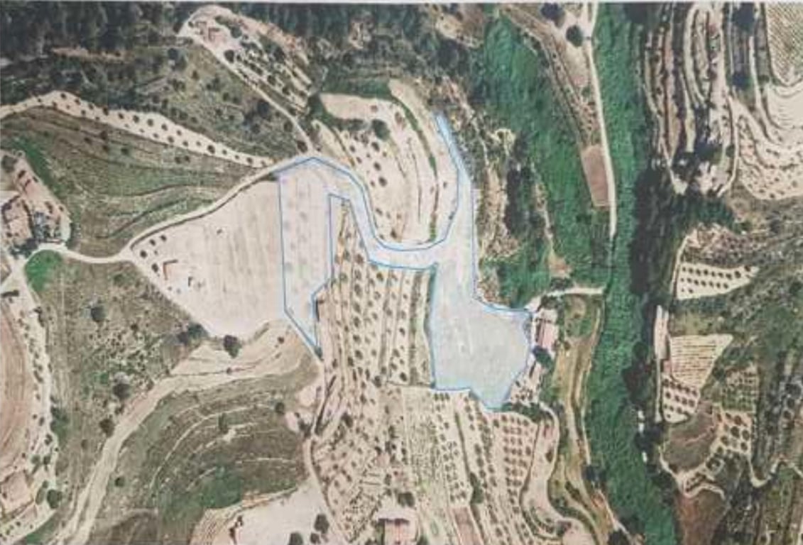 Vue aérienne délimitée du terrain, mettant en évidence la topographie en terrasses et la végétation environnante dans un cadre rural.