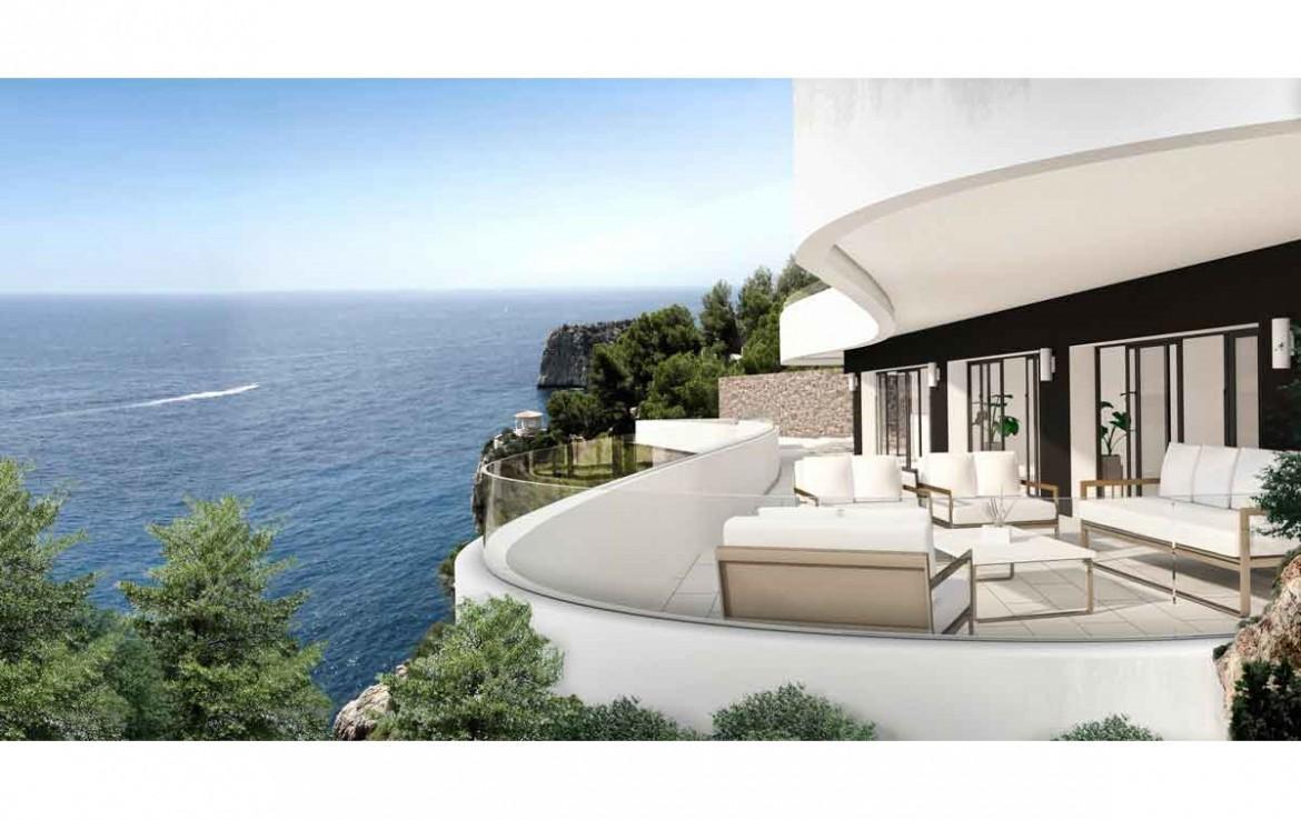 Terrasse incurvée avec garde-corps en verre et mobilier contemporain, offrant une vue panoramique sur la mer Méditerranée et les falaises.