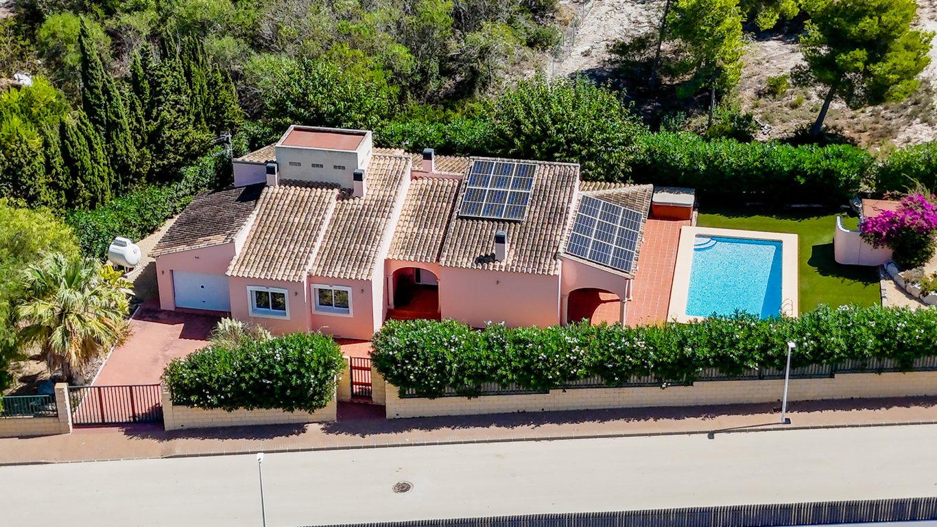 Vue aérienne de la villa de plain-pied, illustrant la piscine privée, les panneaux solaires sur le toit et le terrain clos avec garage et accès sécurisé.