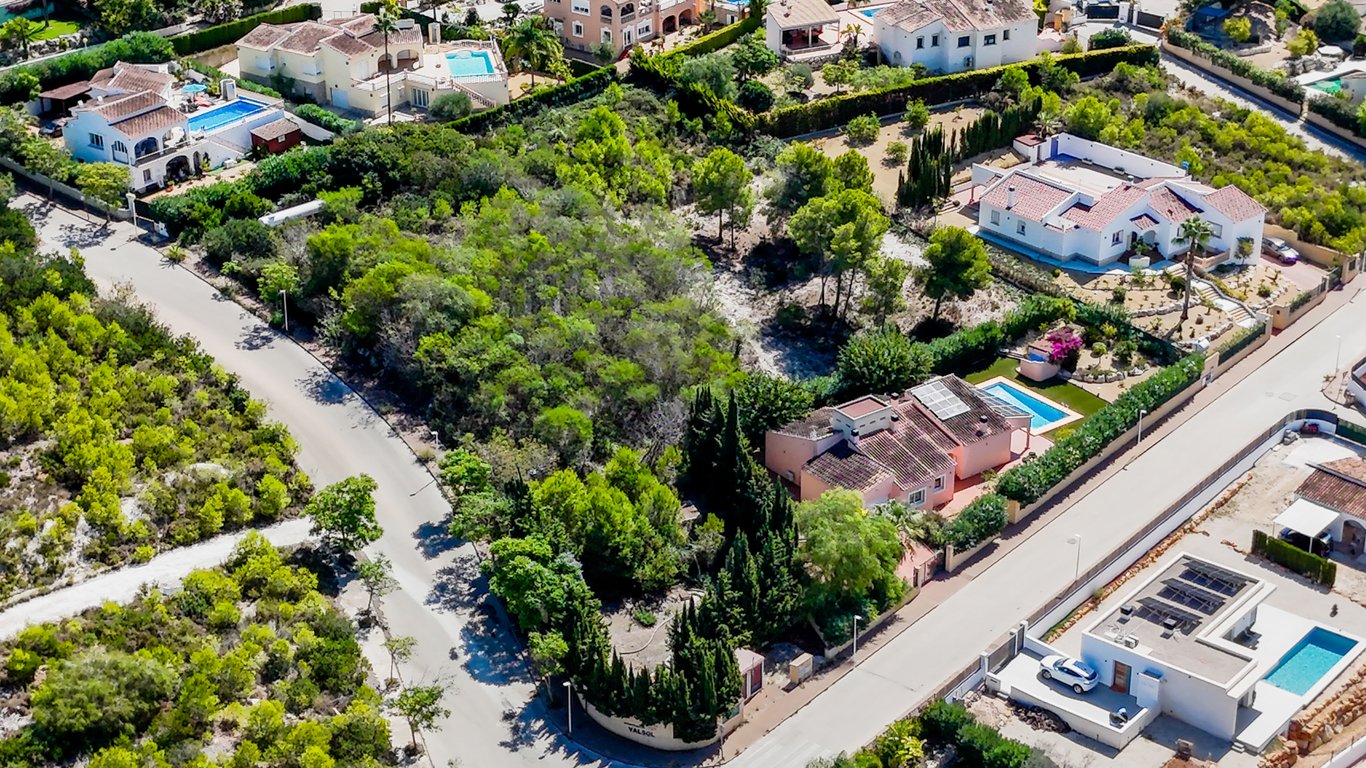 Vue aérienne montrant la disposition de plain-pied, la piscine privée et les panneaux solaires sur le toit au sein d'un terrain plat et clôturé.