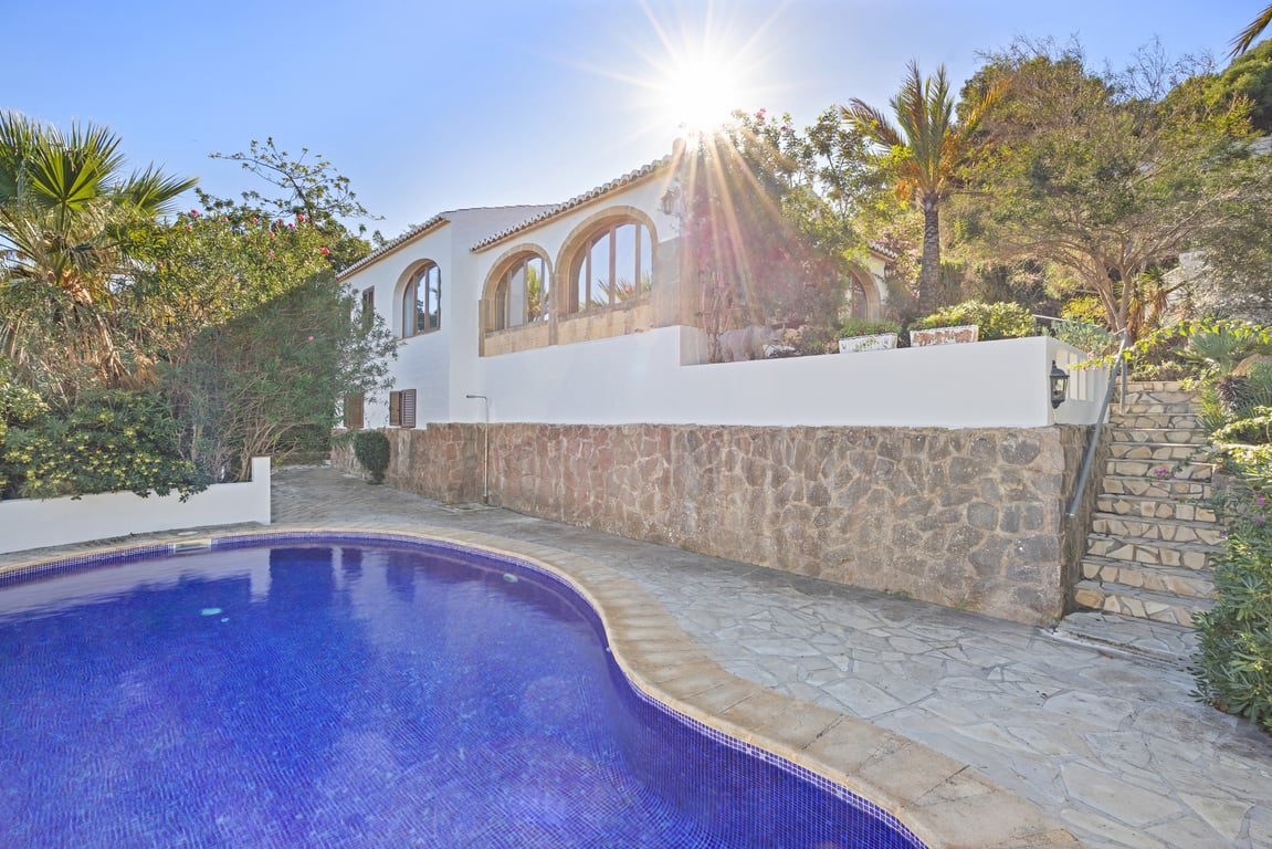 Extérieur de la villa avec piscine privée, murs en pierre naturelle et naya aux arches en pierre Tosca typique de la région.
