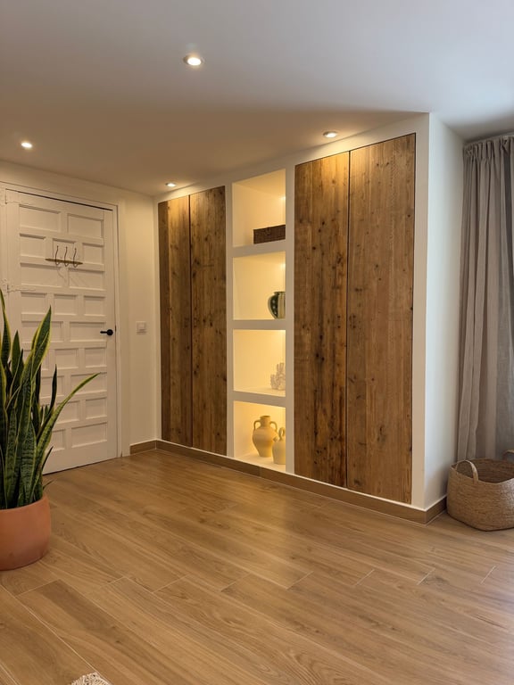 Placard encastré avec portes en bois rustique et niches d'exposition rétroéclairées par LED, sur un sol en grès cérame imitation bois naturel.
