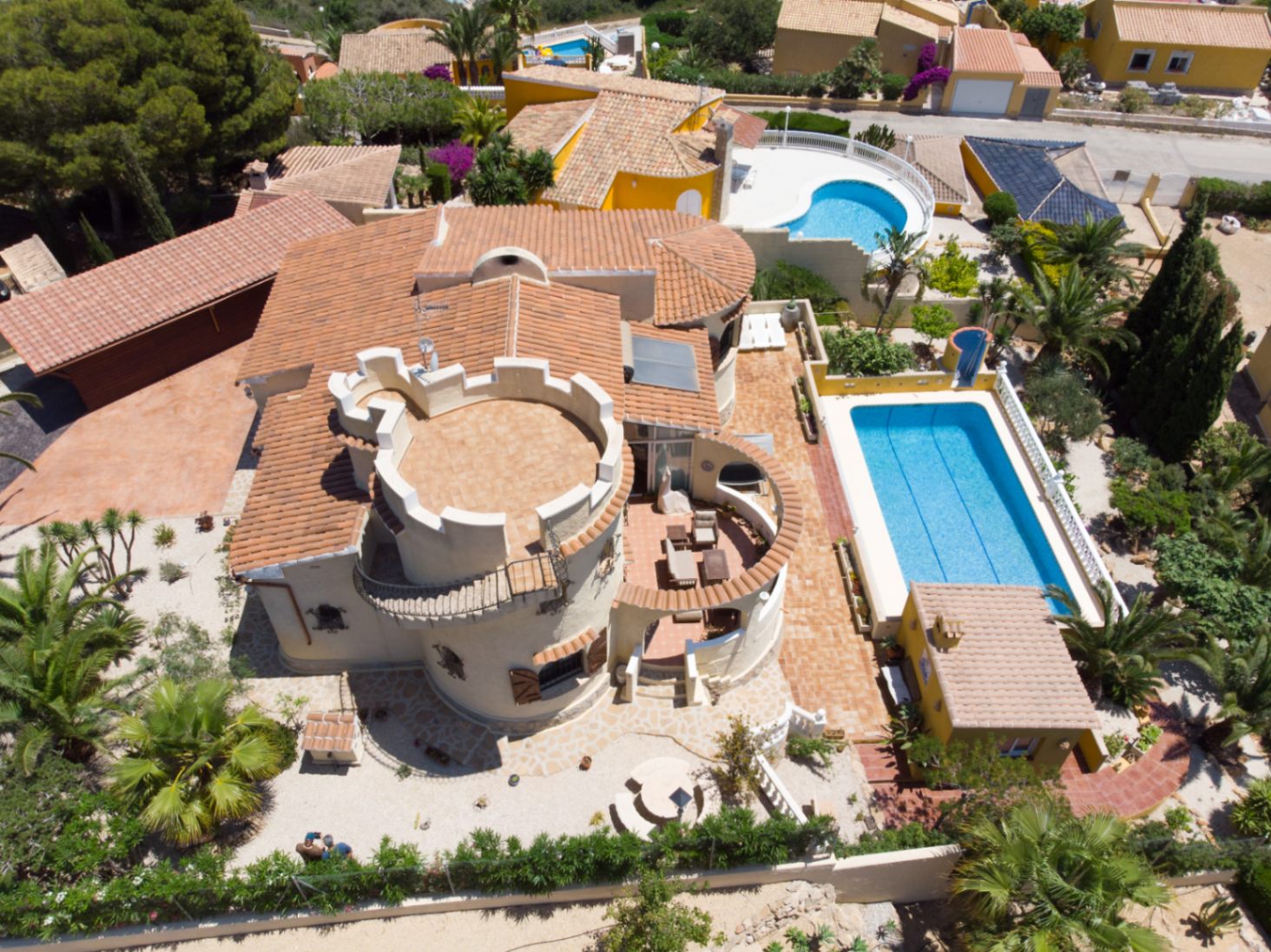 Vue aérienne de la villa révélant sa tour emblématique avec terrasse, la piscine de 10x4 m et les aménagements extérieurs sur une parcelle de 1 030 m².