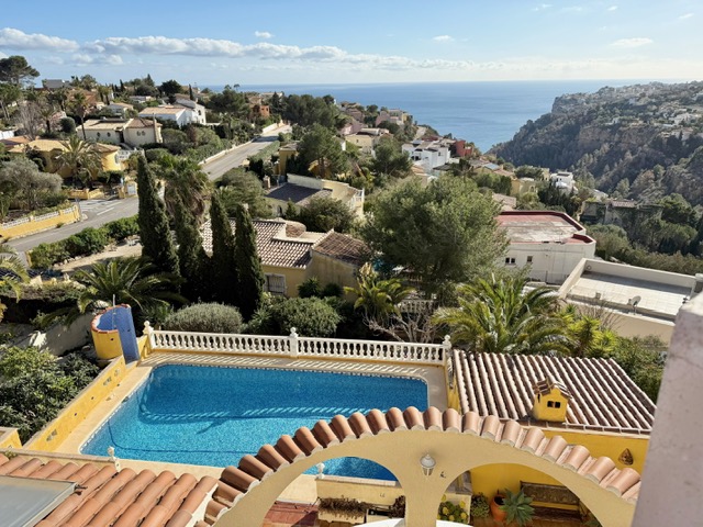 Vue en hauteur de la piscine de 10x4 m avec balustrades blanches, offrant un panorama dégagé sur la mer Méditerranée et le paysage côtier.