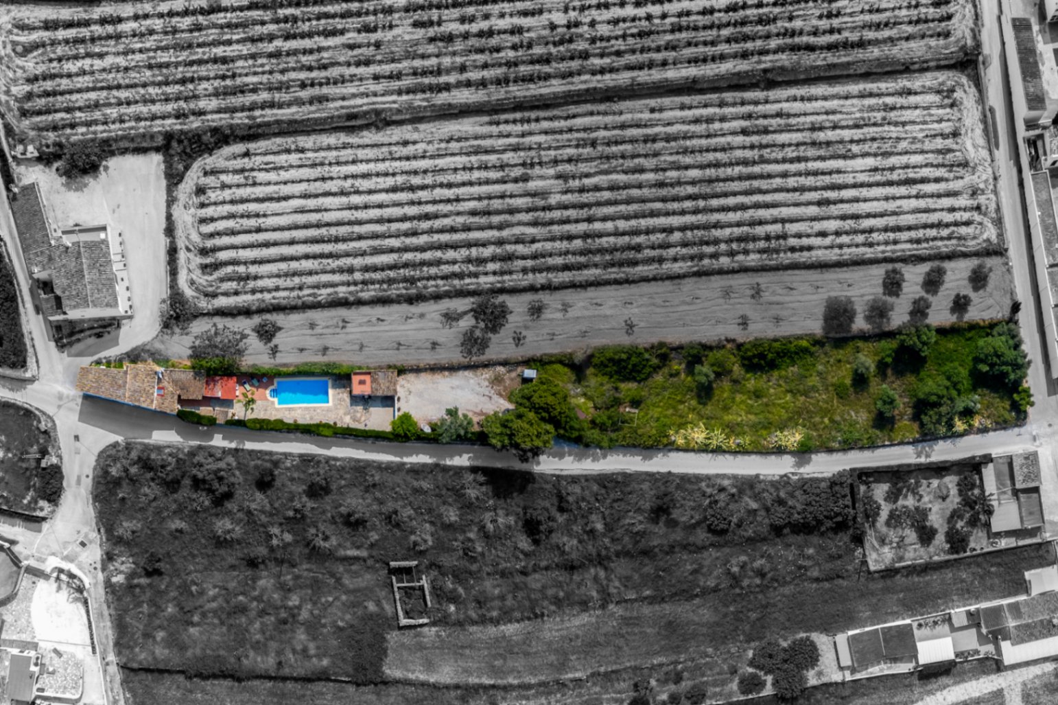 Vue aérienne d'une finca avec piscine à Teulada, entourée de champs et de verdure.