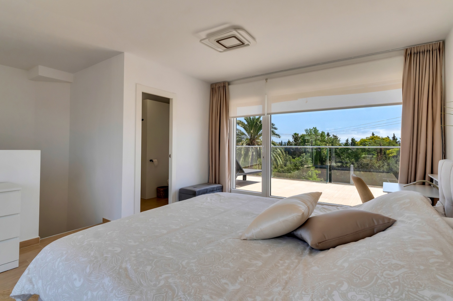 Chambre lumineuse avec accès direct à une terrasse privée et vue dégagée. Dispose de la climatisation intégrée, de sols en bois et d'une salle de bain attenante.