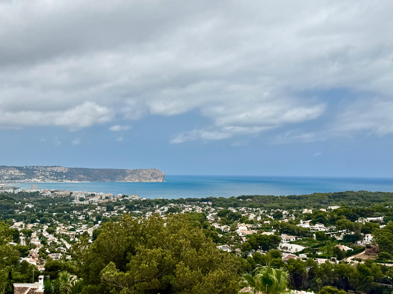 Vues panoramiques surélevées sur la baie de Jávea et le cap de San Antonio, avec la mer Méditerranée et le paysage résidentiel verdoyant.