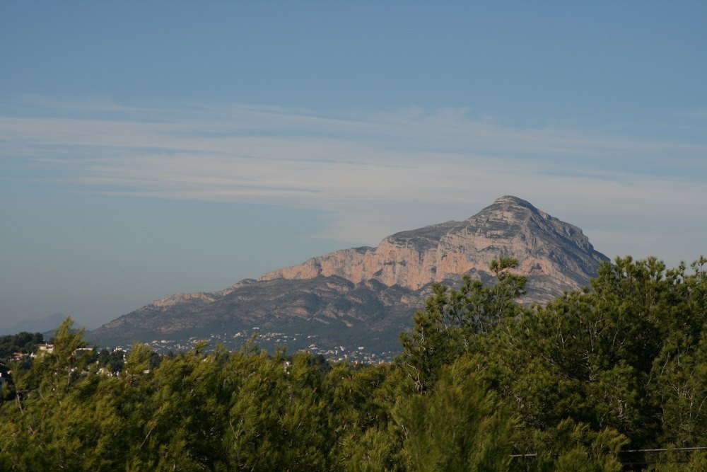 Vue panoramique sur le massif du Montgó depuis le terrain, mettant en valeur les falaises rocheuses s'élevant au-dessus d'une pinède méditerranéenne.
