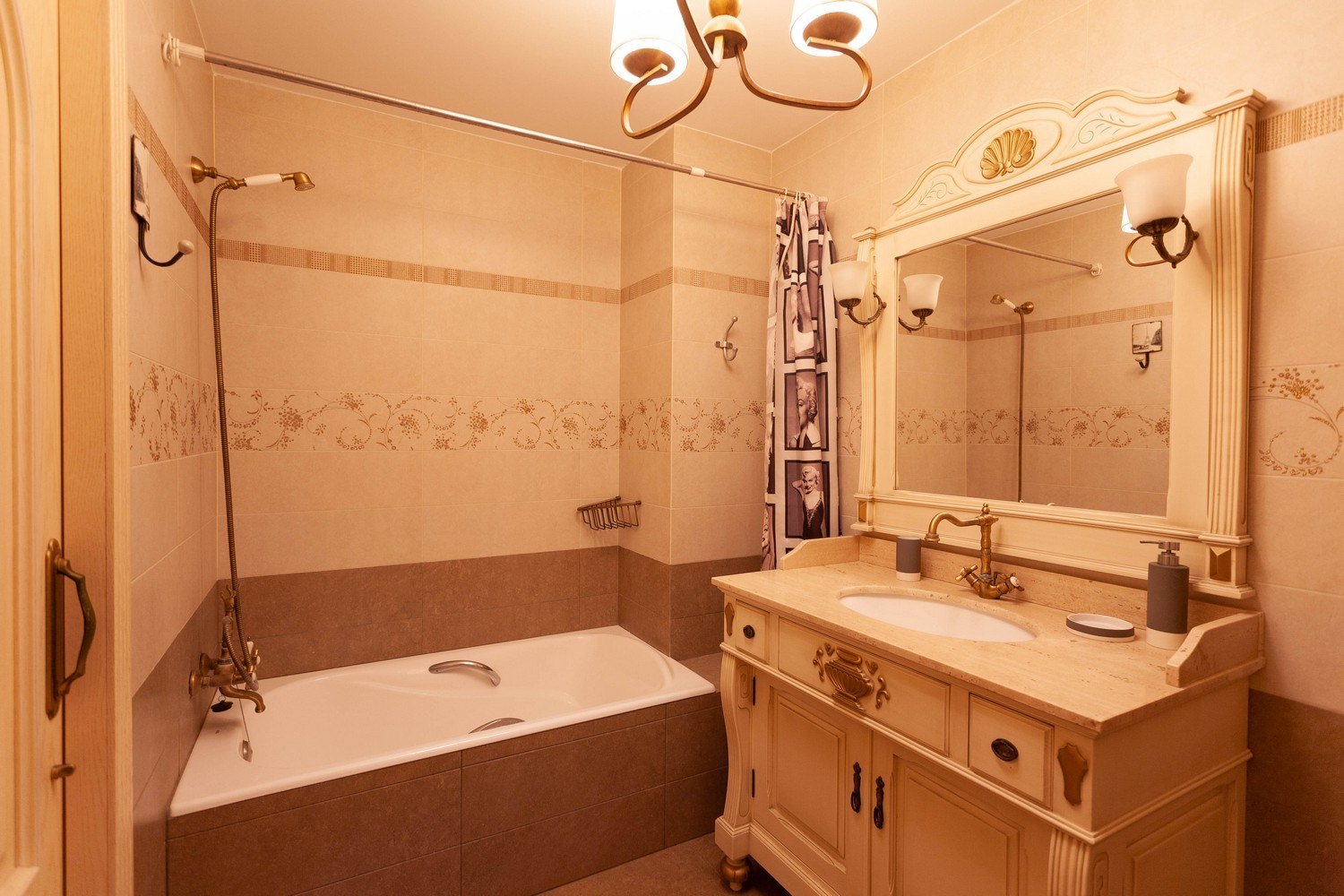 Salle de bain classique avec baignoire, lavabo à comptoir en marbre et miroir orné.