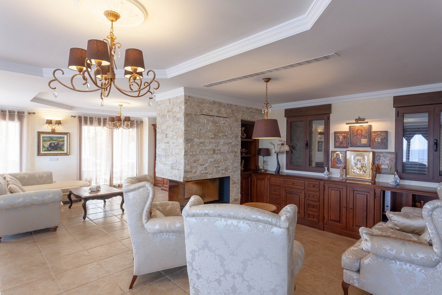 Salon avec cheminée en pierre, mobilier en bois classique et carrelage en céramique.