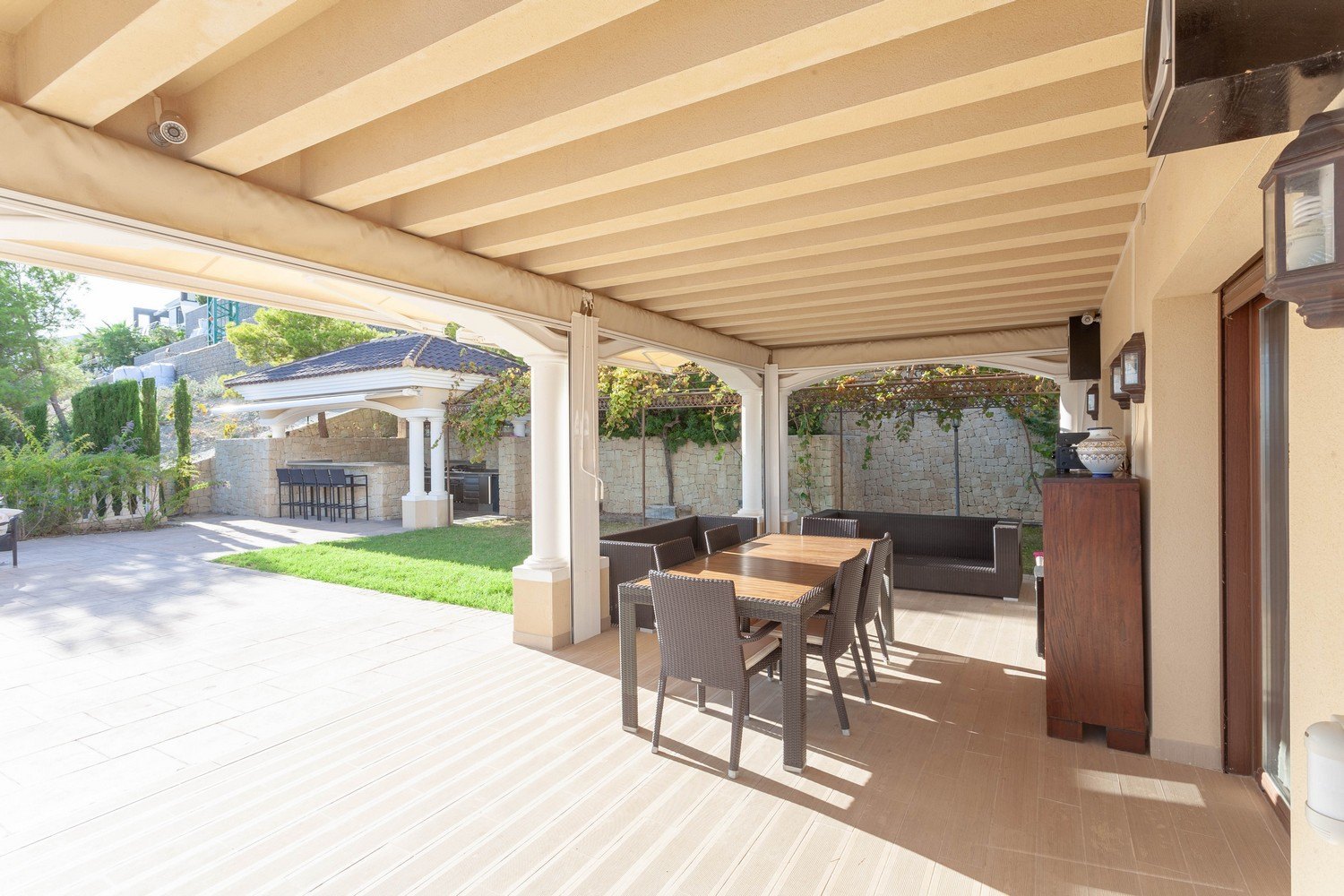 Terrasse couverte avec coin repas et vue sur le jardin avec barbecue à Benissa, Costa Blanca.