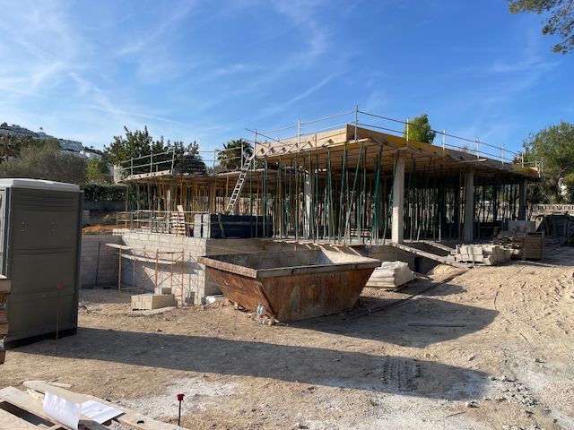 Villa en construction à Moraira. On aperçoit les fondations, les colonnes de soutien et le coffrage du toit par une journée ensoleillée.