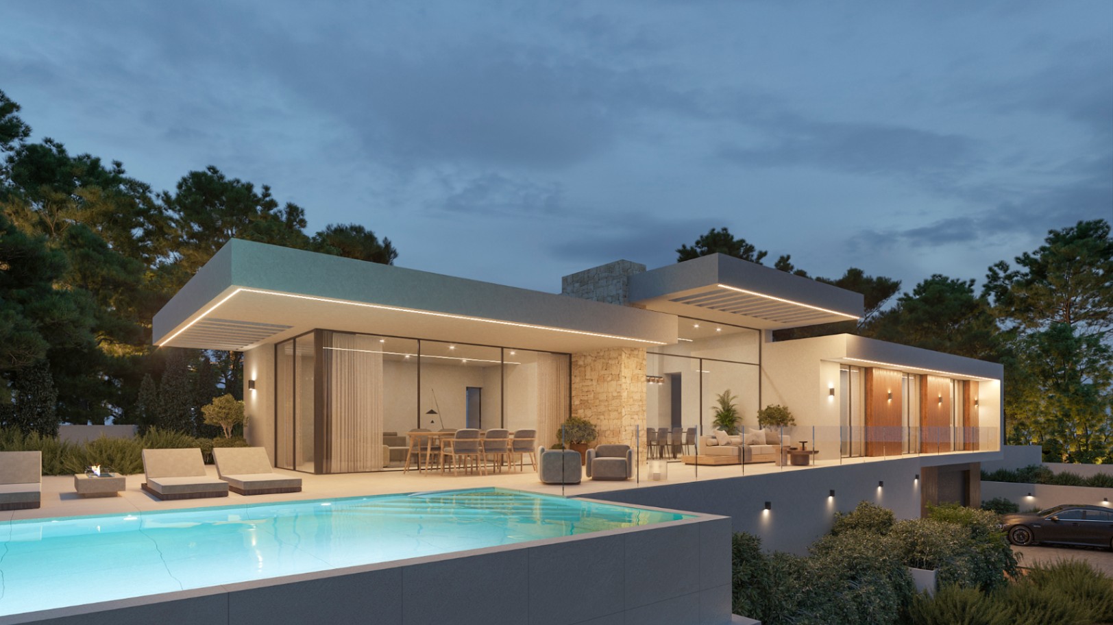 Vue extérieure nocturne de la villa avec piscine à débordement, murs en pierre naturelle et larges baies vitrées révélant un intérieur spacieux et une terrasse éclairée.