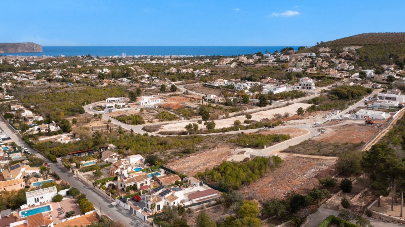 Vue aérienne panoramique du quartier Lomas Del Rey à Jávea, illustrant la proximité de la mer Méditerranée et le cadre résidentiel paisible entouré de pins.