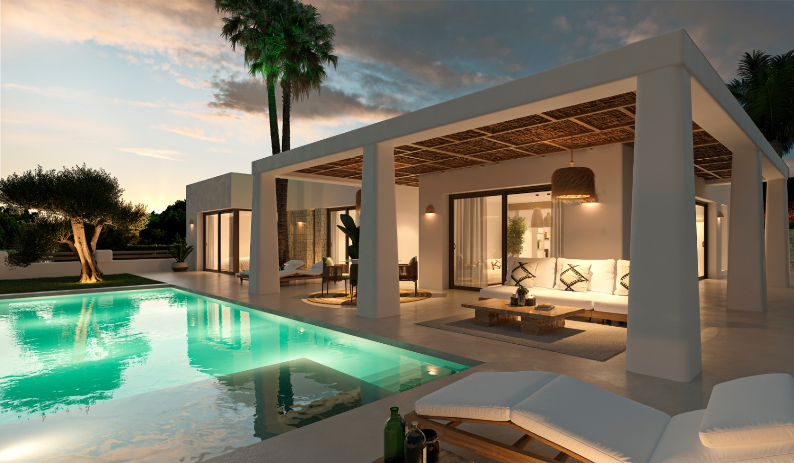 Extérieur de villa de style ibizane avec piscine éclairée, terrasse couverte aux plafonds en roseaux et salon de jardin au crépuscule.