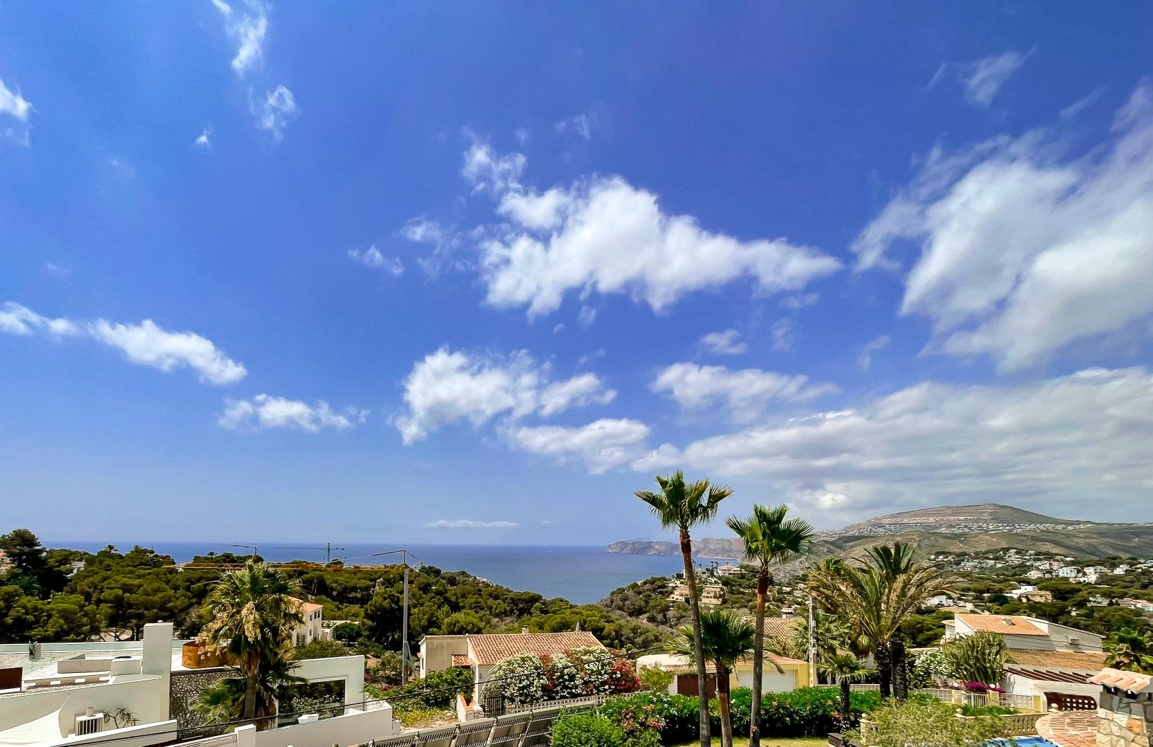 Vue panoramique ininterrompue sur la mer Méditerranée et la vallée, mettant en valeur la végétation indigène et la silhouette côtière de Jávea.