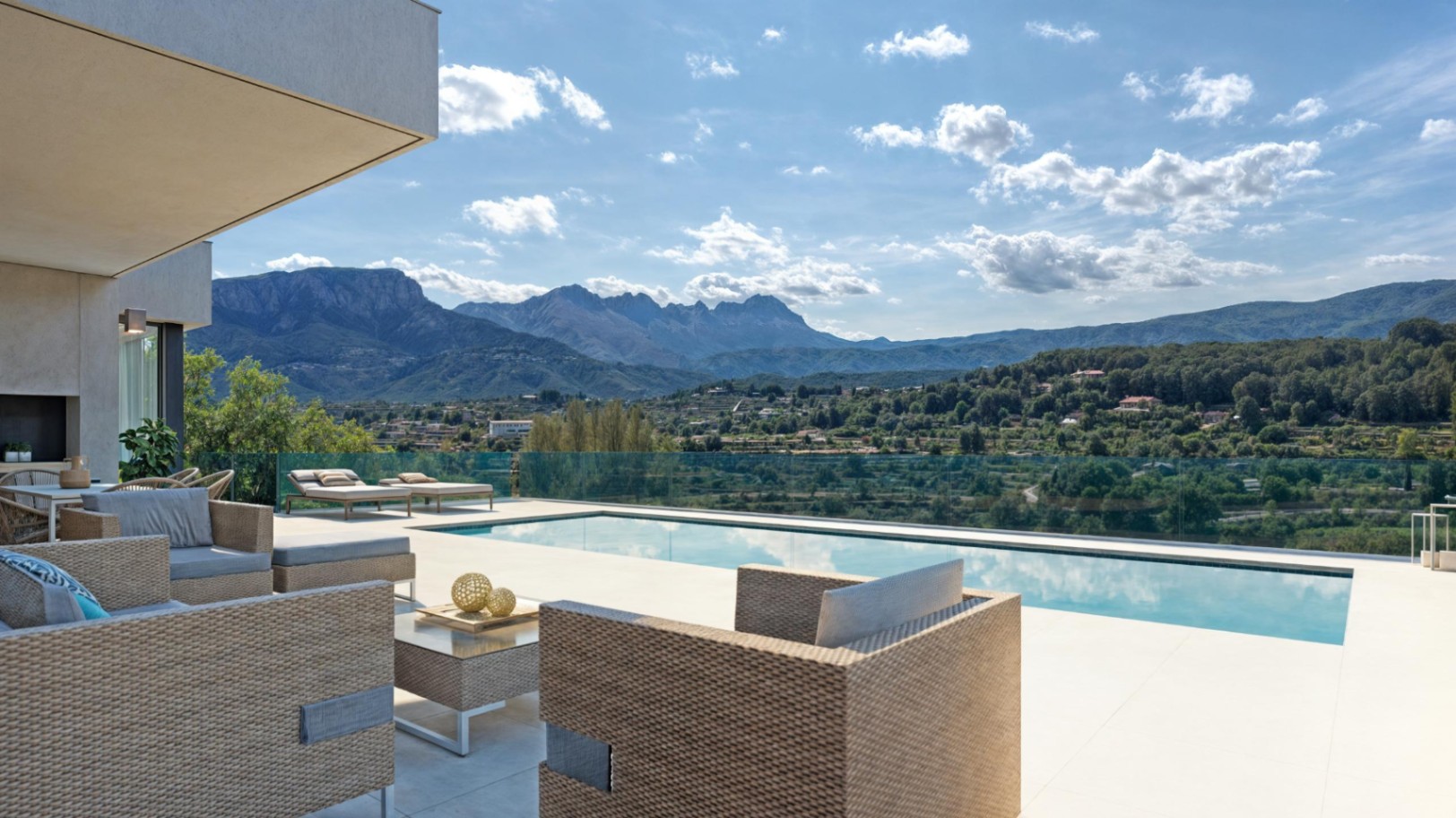 Terrasse extérieure avec piscine privée, salon de jardin en rotin et vue panoramique sur la Sierra de Bernia et la vallée.