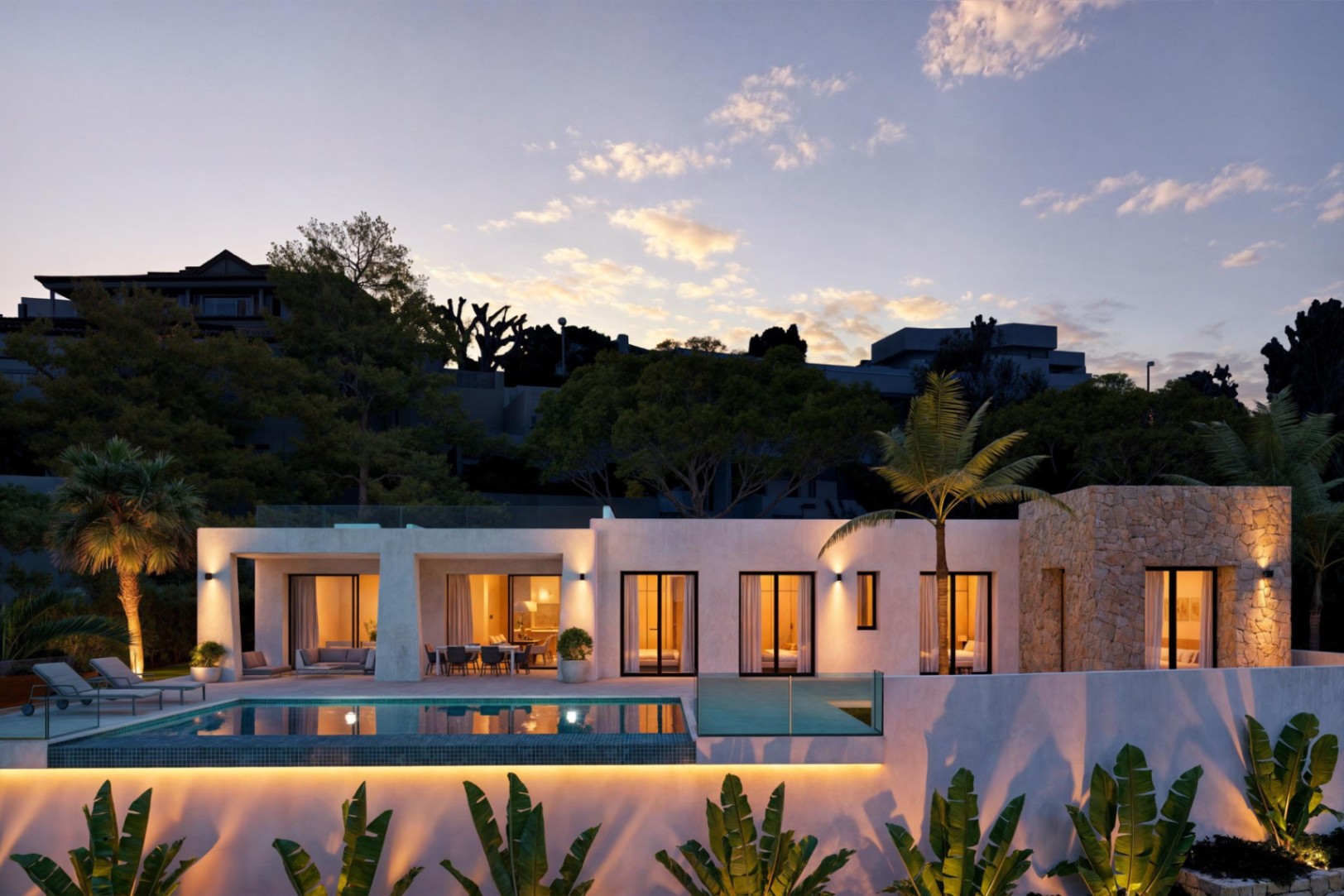 Vue extérieure de la villa avec piscine illuminée et façade en pierre au crépuscule.