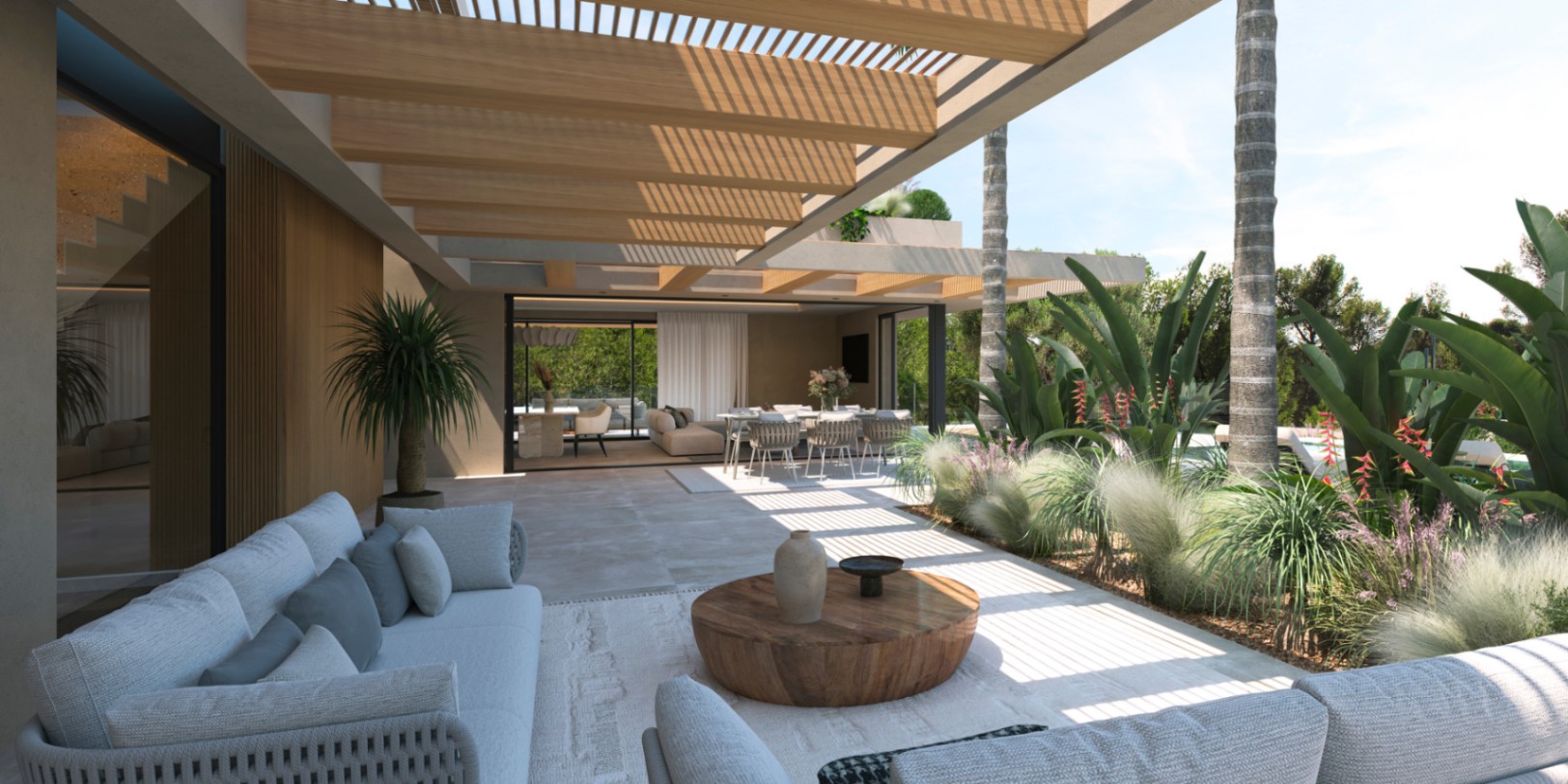Terrasse couverte avec pergola en bois et sol en pierre, reliant le salon extérieur à l'espace de vie intérieur par de larges baies vitrées coulissantes.