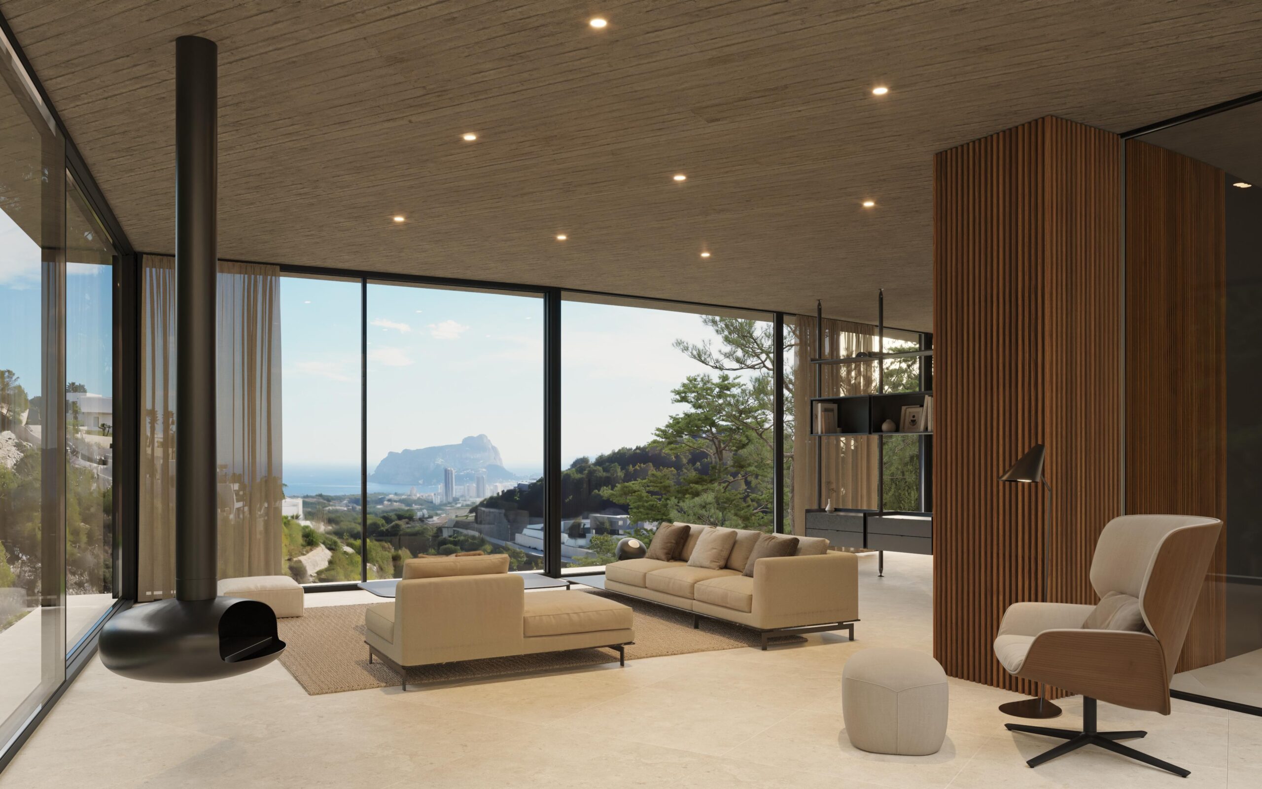 Salon moderne avec cheminée suspendue, plafonds en béton et baies vitrées offrant une vue panoramique sur la côte méditerranéenne et le Peñón de Ifach.
