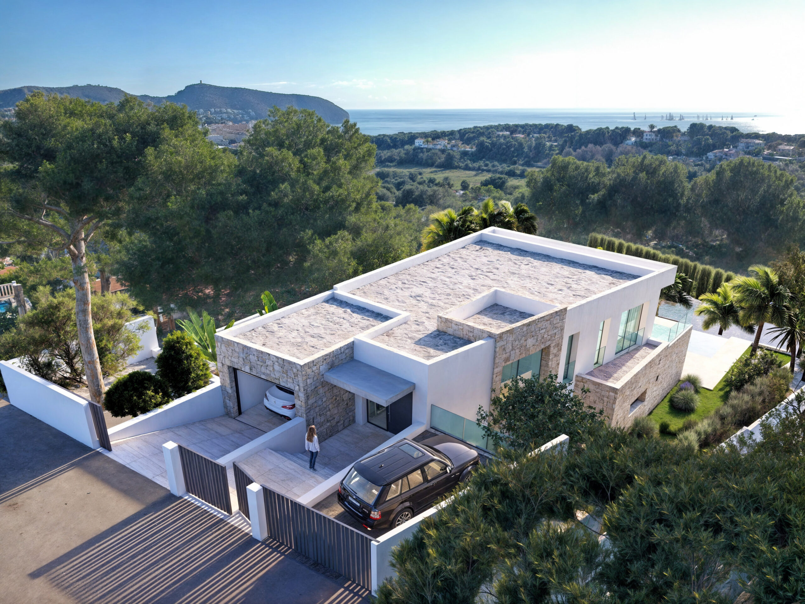 Extérieur d'une villa moderne avec parement en pierre naturelle, entrée sécurisée et toits plats, offrant une vue panoramique sur la mer Méditerranée et la nature.