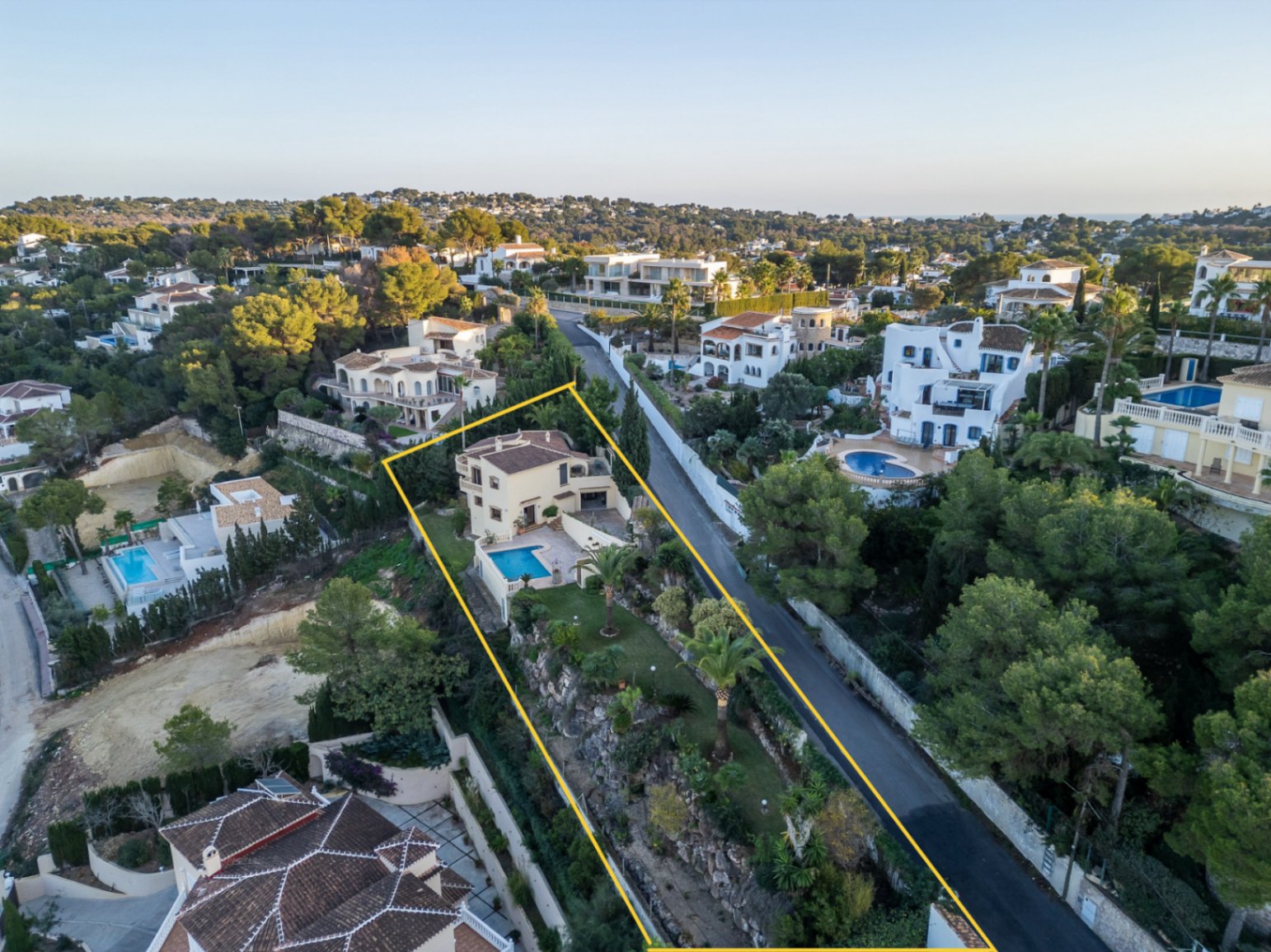 Vue aérienne de la propriété délimitée, présentant la villa méditerranéenne, sa piscine privée et son jardin en terrasses avec palmiers à Costa Nova.
