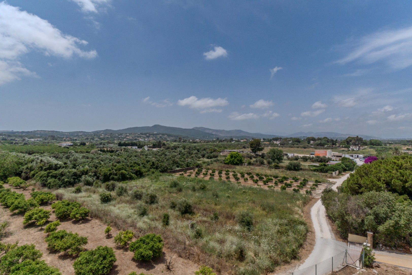 Vue panoramique à 180° depuis la propriété sur la vallée de Jávea, englobant des vergers agricoles et les collines lointaines de Benitachell.
